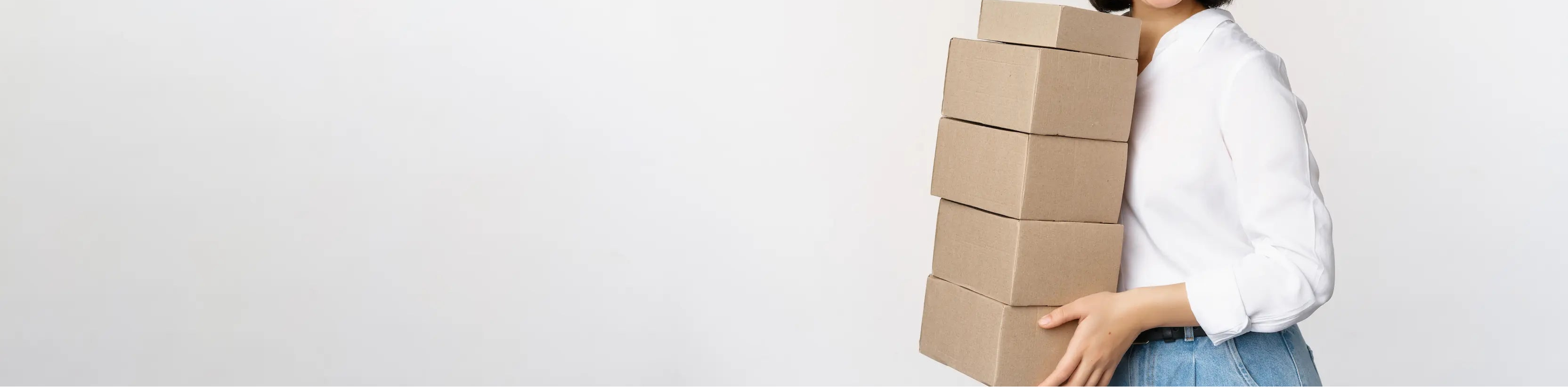 Woman holding a stack of cardboard boxes against a white background
